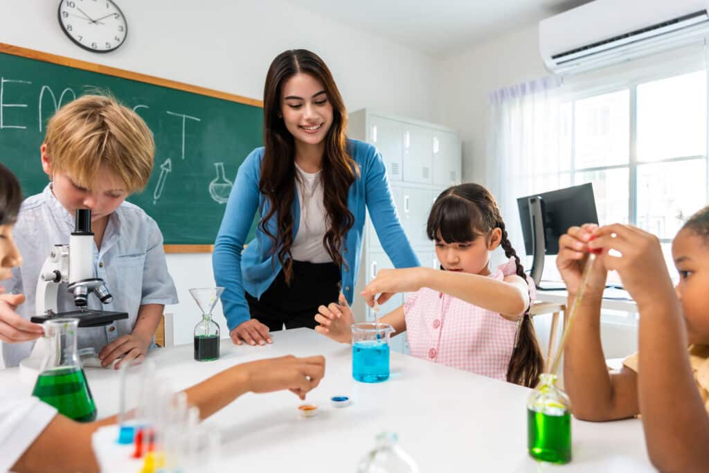 Students learn with teacher in classroom.