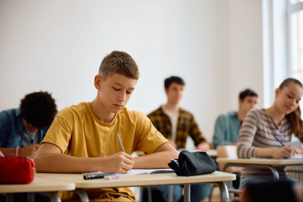 Students focused during an exam in a classroom setting.