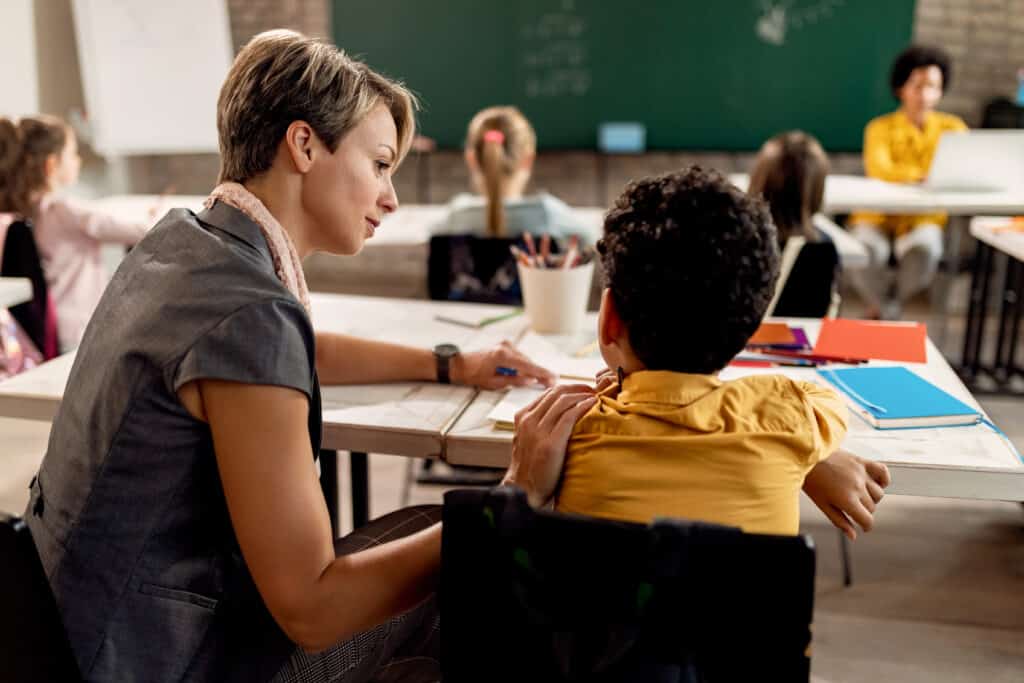 Elementary teacher assisting a schoolboy childhood trauma concept