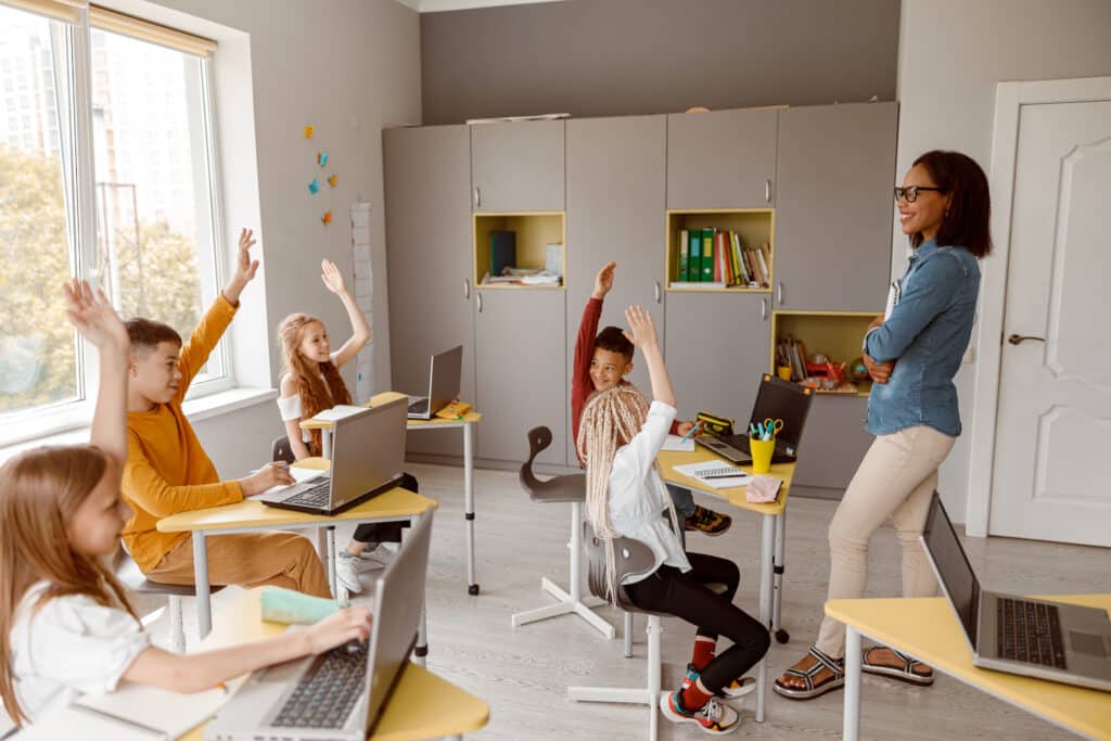 kidsd sitting at desks in classroom during lesson