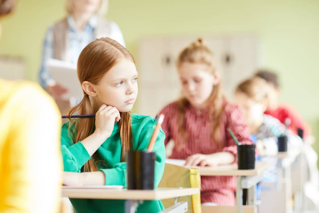 trauma-informed teaching concept Sad student girl in classroom