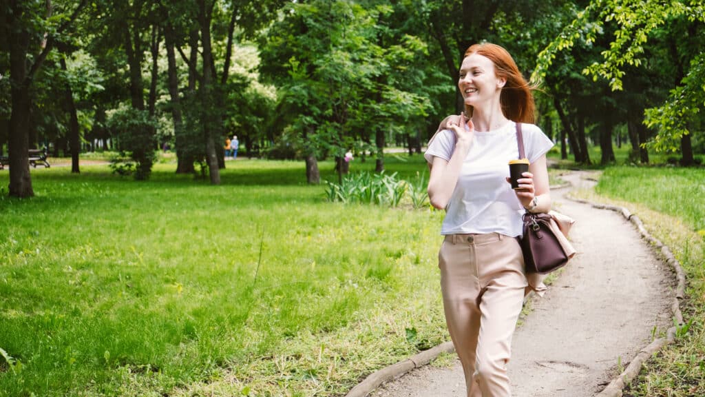 positive psychological concept. Business woman enjoying life on the background of green trees in the park.