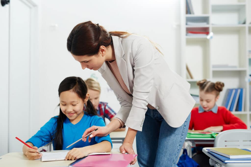 Teacher performing informal assessment with schoolgirl