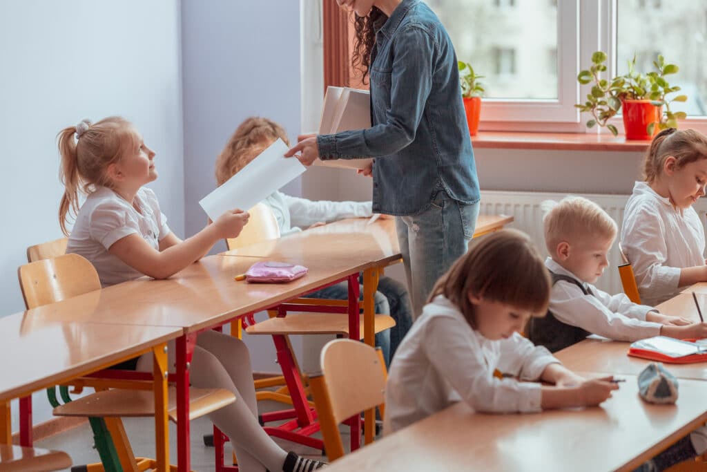 standards based education concept - Teacher gives the student a tested and graded test