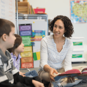 Teacher holding a book talking with students