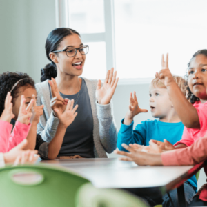 teacher clapping with kids around her