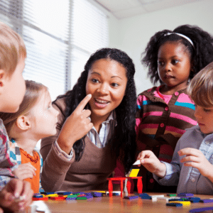 teacher happily pointing her face to her young students