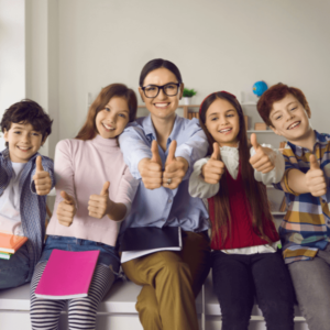 Teacher and students happily sitting together.