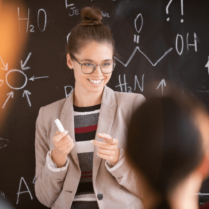 teacher in front holding a chalk