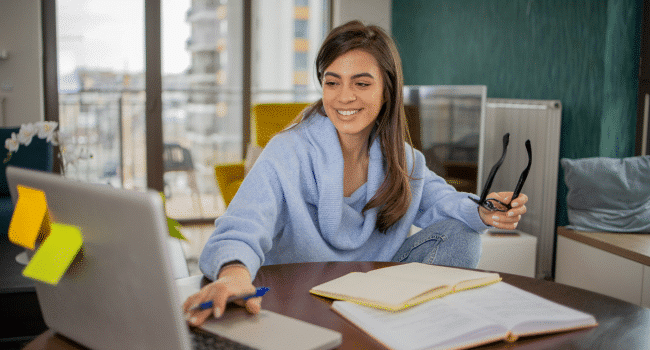 woman typing on laptop smiling