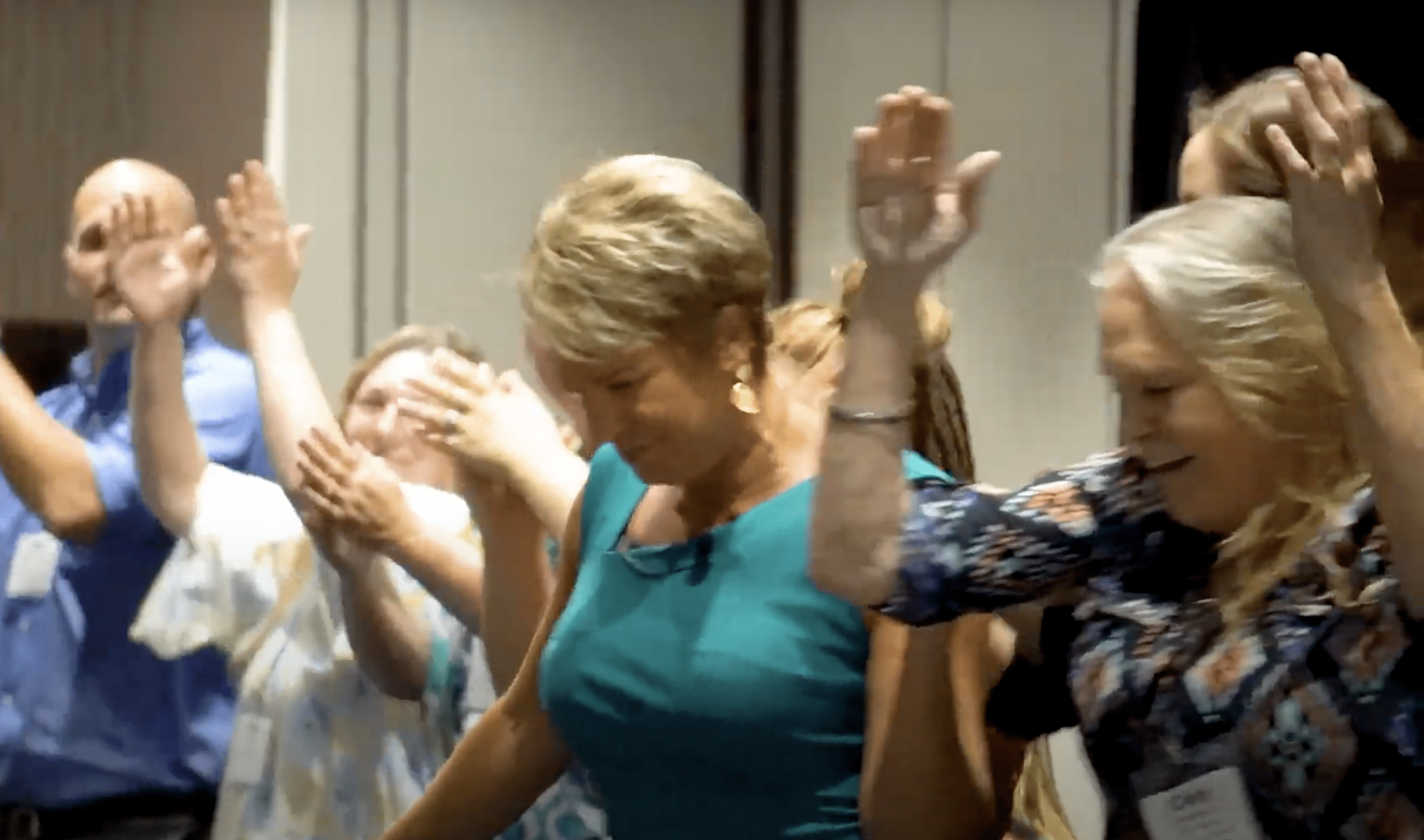 Kim Strobel as keynote speaker on stage with teachers