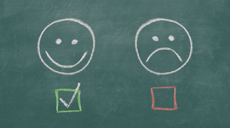 Chalkboard with happy and sad faces drawn on it