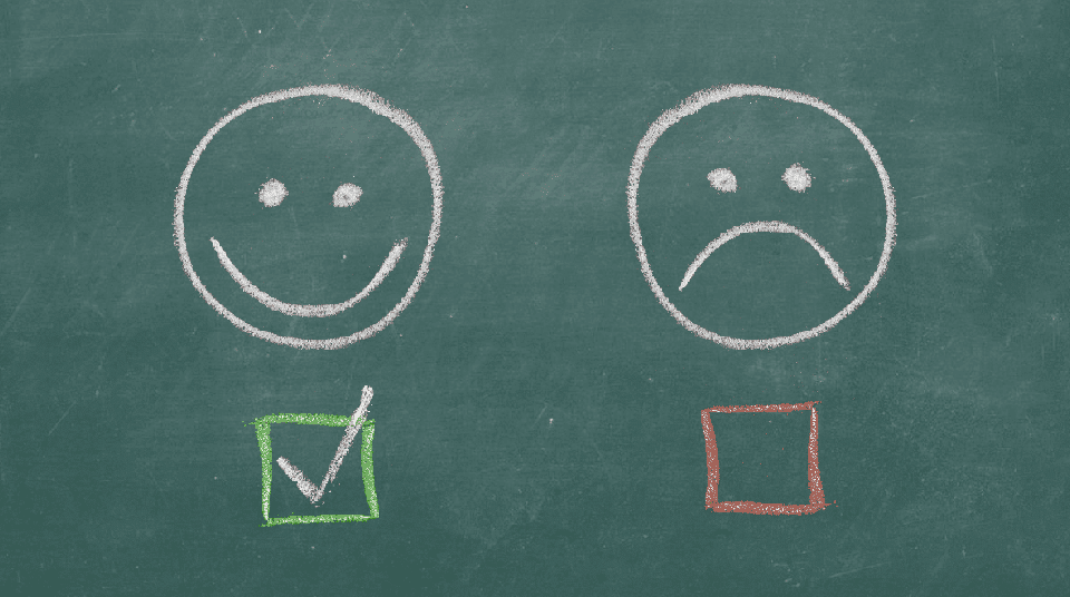 Chalkboard with happy and sad faces drawn on it